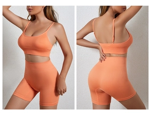 Detail van de oranje geribbelde fitnessset met dunne bandjes en korte broek met hoge taille