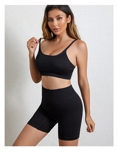 Detailopname van zwarte geribbelde sport-bh en biker-shorts met hoge taille op een model