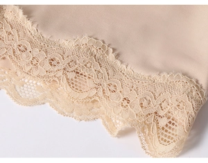 Macro detail of seamless nude body shaper featuring exquisite floral lace hem and elastic fabric
