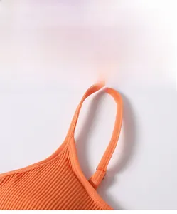 Detailopname van de oranje geribbelde sportbeha met verstelbare metalen gespen