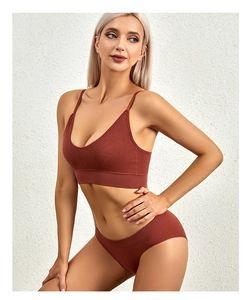 Detailed texture of seamless ribbed V-neck lingerie set in deep brick red color