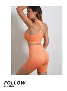 Dettaglio del set da yoga in maglia a coste arancione acceso con pantaloncini e reggiseno