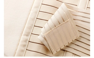 Macro shot of breathable beige abdominal binder with elastic stripes and velcro strap