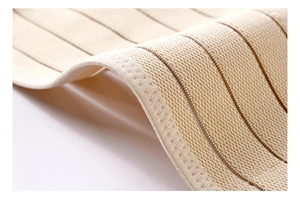 Macro detail of breathable skin-colored waist cincher fabric with reinforced stitching