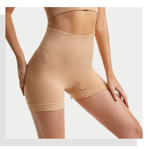Dettaglio di pantaloncini da yoga beige senza cuciture a vita alta con trama a coste snellente