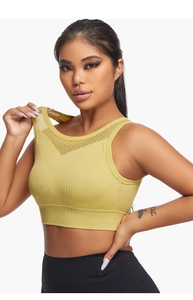 Close-up of breathable mesh detailing and ribbed hem on a yellow yoga sports bra