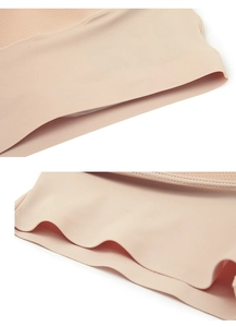 Detail of skin-toned tummy control shapewear with seamless edges and breathable mesh fabric