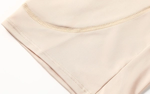 Close-up of seamless reinforced stitching on high-waist beige body shaping shorts