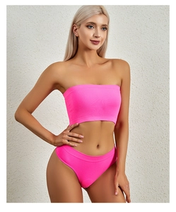 Detailed texture of neon pink ribbed fabric on a seamless strapless lingerie set