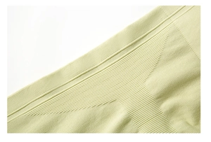 Detailed close-up of light green ribbed knit fabric on a stretchy yoga jumpsuit
