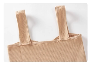 Close-up of ribbed knit texture and reinforced shoulder strap on nude mini dress