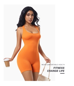 Detail of seamless bright orange one-piece fitness romper with racerback design