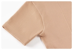 Close-up of khaki ribbed knit fabric showing seamless shoulder stitching and cuff details
