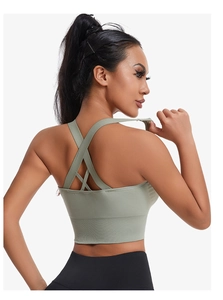 Détail du soutien-gorge de sport vert sauge montrant les bretelles croisées et l'ourlet