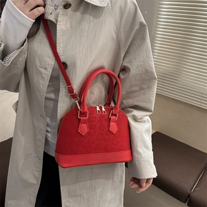 Sac à main rouge en forme de coquillage avec motif léopard porté en bandoulière chic