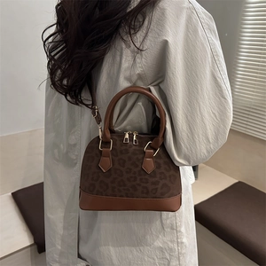 Sac à main chic avec motif léopard, poignées en cuir marron et bandoulière réglable