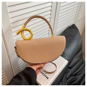 Close-up of beige saddle bag with gold ring hardware and Fashion & Bags text details