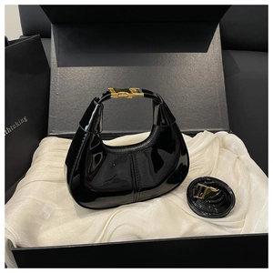 Détail du sac hobo croissant en cuir verni noir avec boucle dorée et bandoulière