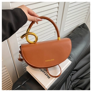 Detail of caramel brown semi-circle bag with distinctive golden knotted metal handle