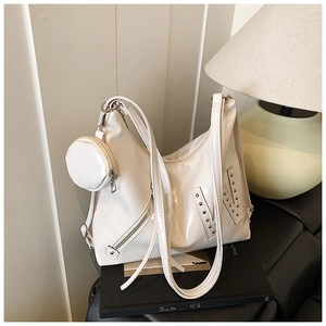 Detail van witte glanzende draagtas met zilveren studs en ronde mini-muntenzakje