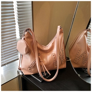 Detail van roze laksnoer shopper met metalen W-motief van studs en mini-portemonnee