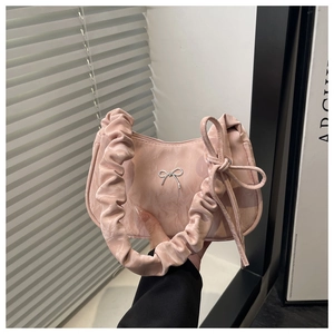Détail d'un sac rose clair avec boucle papillon argentée et anse froncée plissée