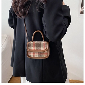 Detail view of mini plaid woolen crossbody bag shown on model for size and fit