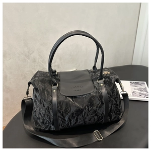 Détail du sac de voyage noir à texture plissée métallique avec bandoulière réglable