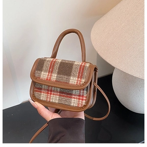 Detail of wool plaid handbag with brown PU handle and textured checkered fabric finish