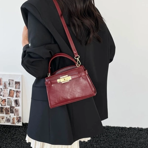 Sac bandoulière bordeaux à texture crocodile avec fermoir doré et poignée supérieure
