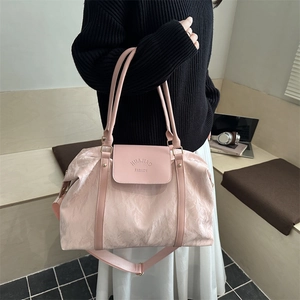 Grand sac de voyage rose avec texture gaufrée et bandoulière réglable pratique