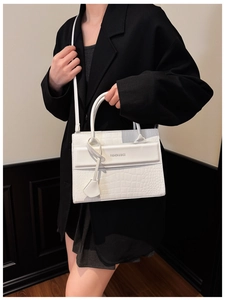 Close-up of white crocodile pattern handbag with Fashion & Bags text on professional suit