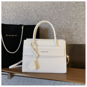 Close-up of white crocodile pattern texture with Fashion & Bags print on shoulder bag