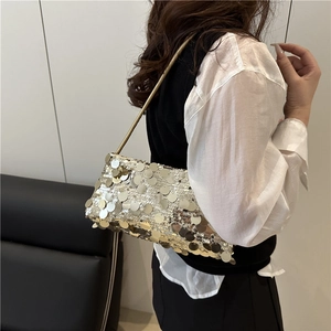 Elegant champagne sequined shoulder bag with metallic strap worn by a model