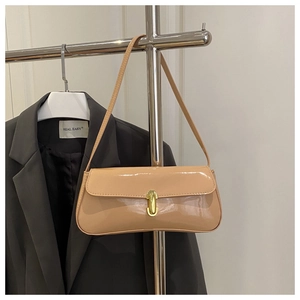Gros plan détaillé du sac baguette en cuir verni beige avec fermoir en métal doré chic