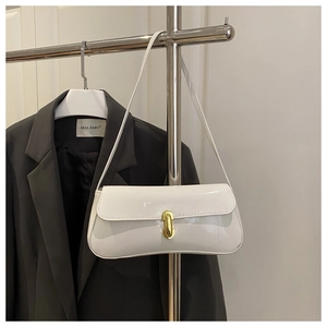 Détail du sac sous le bras en cuir verni blanc avec boucle ovale en métal doré chic