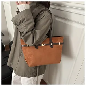 Détail du sac cabas vintage en daim marron avec anses fines et fermoir doré rotatif