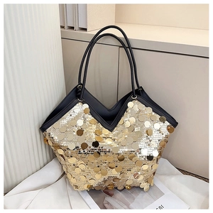 Detailed view of large gold sequins on a black leather tote bag with V-shaped top