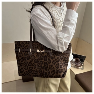 Détail du sac cabas à imprimé léopard avec boucle dorée et bande décorative marron