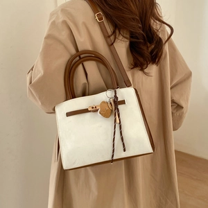 Elegant white PU tote bag with brown leather accents and a metal twist lock closure