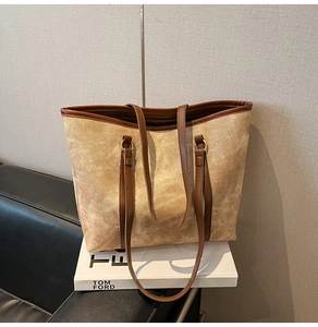 Macro detail of high-capacity tote bag with vintage marble texture and brown leather straps