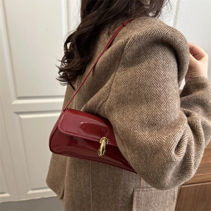 Sac sous le bras rétro en cuir verni bordeaux avec fermoir doré sur mannequin