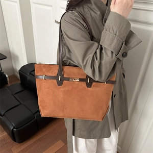 Sac fourre-tout en daim caramel avec lanières en cuir et fermoir doré porté par le mannequin