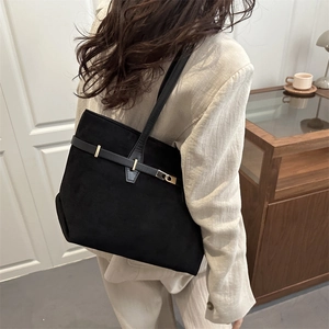 Sac fourre-tout minimaliste en daim noir avec boucle dorée présenté dans un décor chic