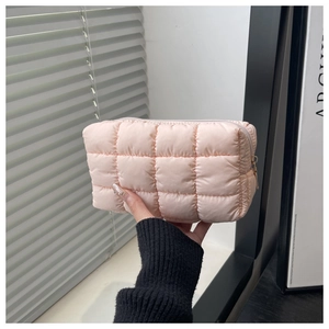 Detail der rosa gesteppten Kosmetiktasche mit Daunenfüllung und Reißverschlussstruktur