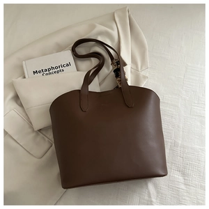 Close-up of brown minimalist tote bag with printed silk scarf detail and long straps