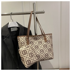 Close-up of printed tote bag set with monogram pattern and matching small pouch