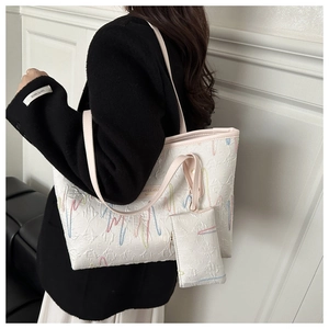 Detail of white tote bag with colorful wave embroidery and matching mini pouch bag