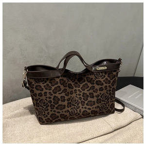 Macro detail of luxury leopard and rose print tote bag with premium leather handles