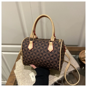Detail view of large Boston bag featuring geometric pattern and red contrast edge handles